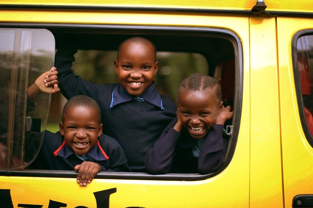 Three School of St Jude students saying hello from a school bus. Three School of St Jude students saying hello from a school bus.