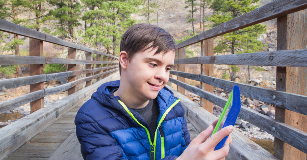A boy with autism and Down's Syndrome using a tablet app A boy with autism and Down's Syndrome using a tablet app