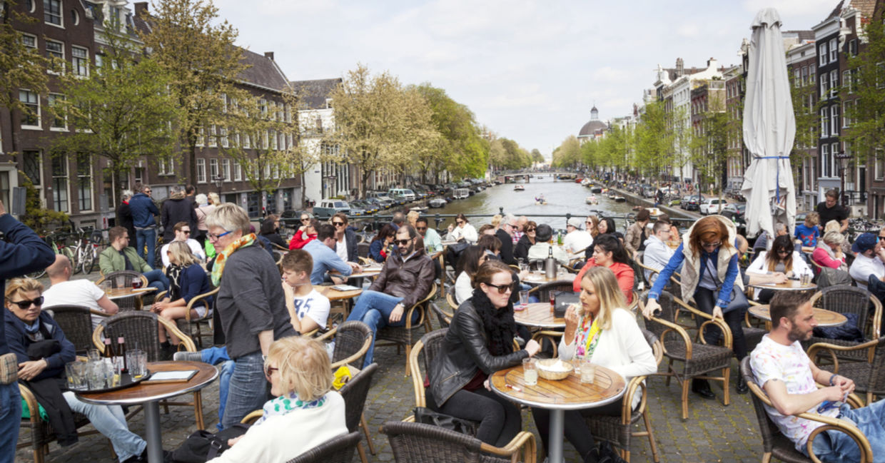 People enjoy a gezellig life sitting in an outdoor cafe Amsterdam. People enjoy a gezellig life sitting in an outdoor cafe Amsterdam.