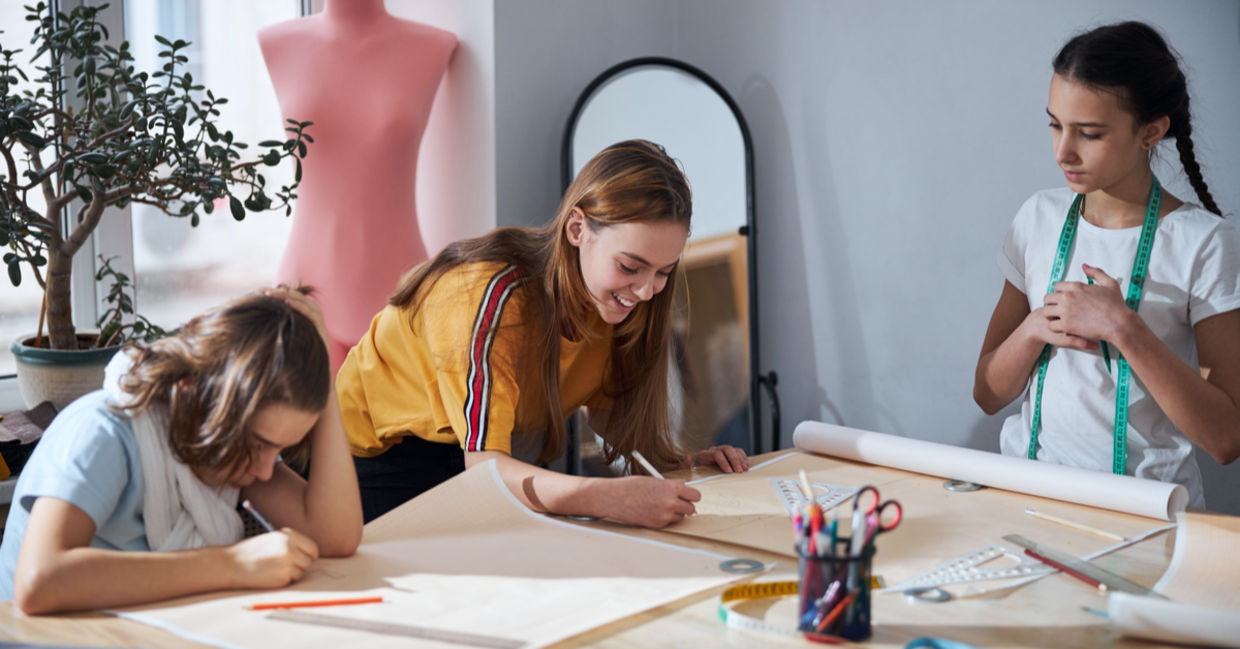 Cute girls drafting sewing patterns for dressmaking. Cute girls drafting sewing patterns for dressmaking.