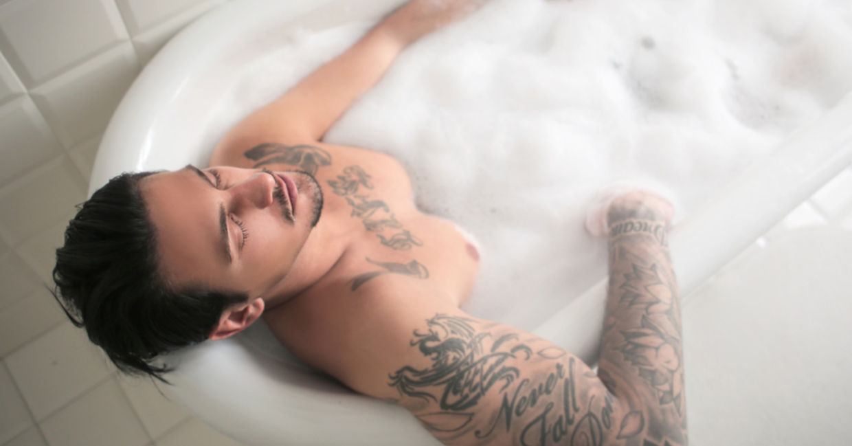 An athletic man soaks his muscles in a warm bath. An athletic man soaks his muscles in a warm bath.