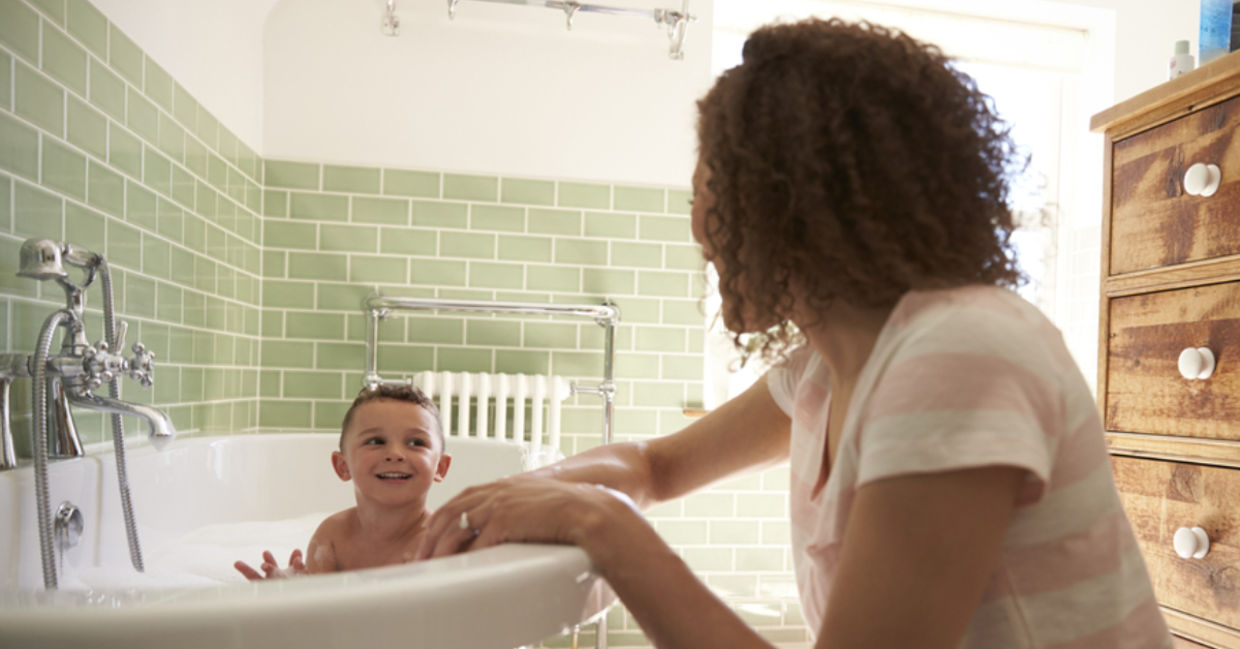A mother helps bathe her toddler son. A mother helps bathe her toddler son.