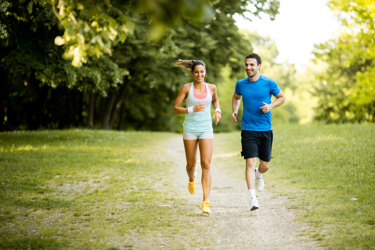 A young couple jogs in a park. A young couple jogs in a park.