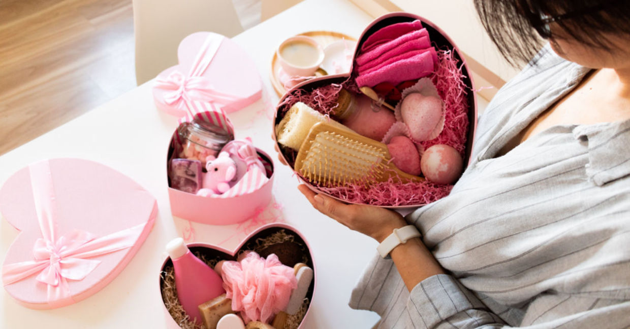 A woman holds a gift of luxurious home spa items. A woman holds a gift of luxurious home spa items.