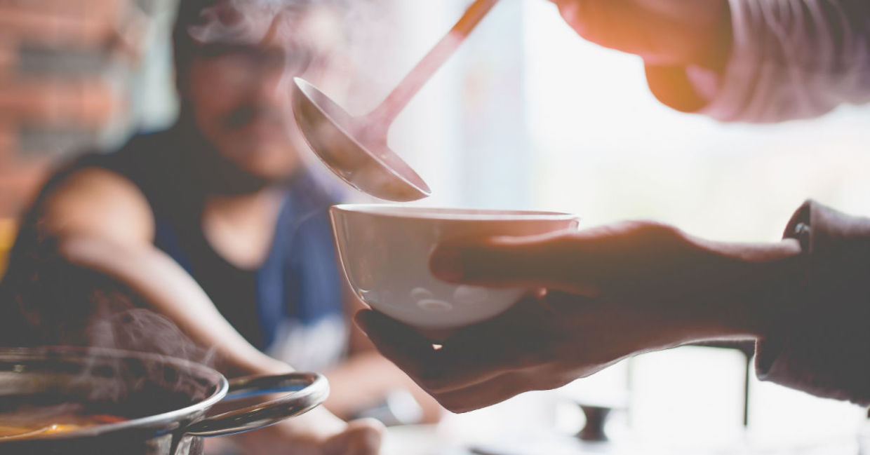 A woman warms up with a hearty soup. A woman warms up with a hearty soup.