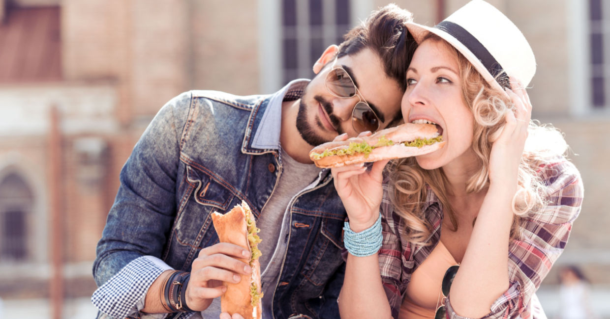 Couple enjoying a sandwich lunch outside. Couple enjoying a sandwich lunch outside.