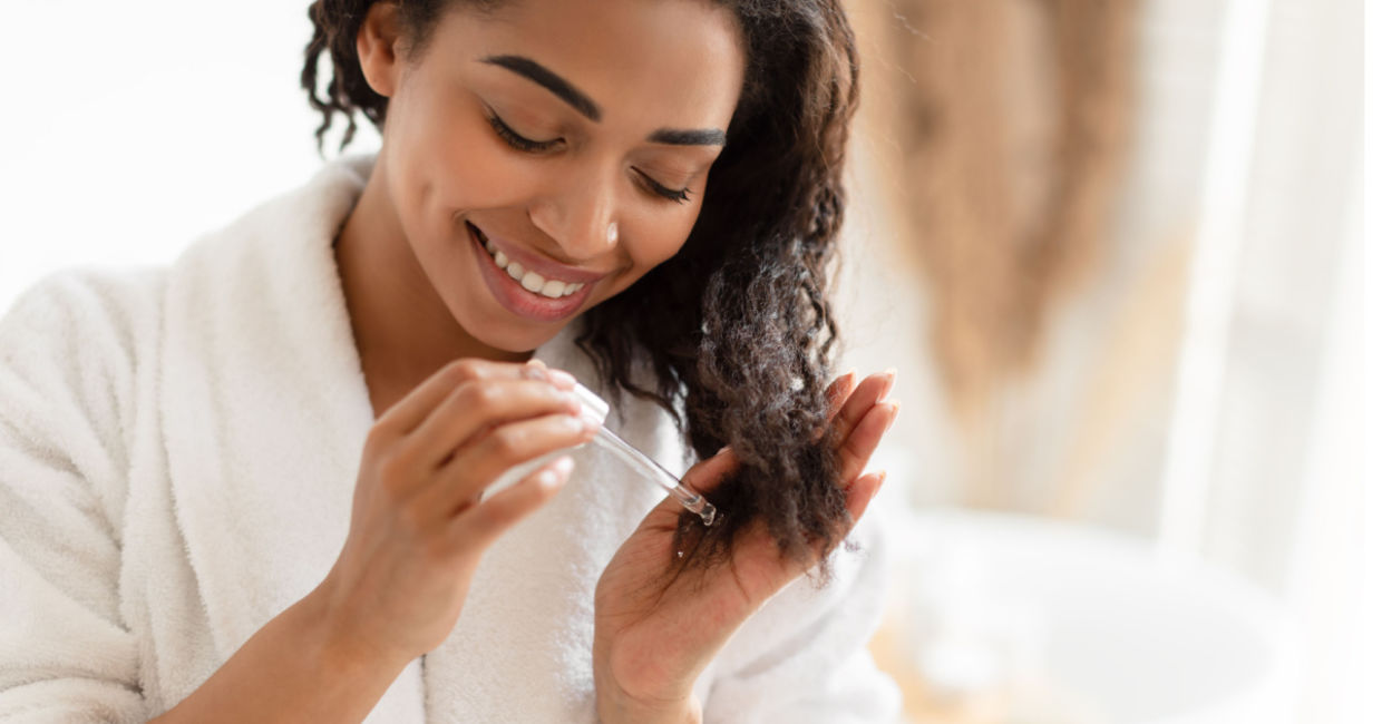 Woman using an organic oil in her hair. Woman using an organic oil in her hair.