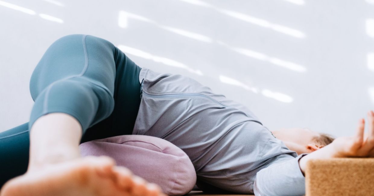 Practicing the supine twist yoga pose. Practicing the supine twist yoga pose.