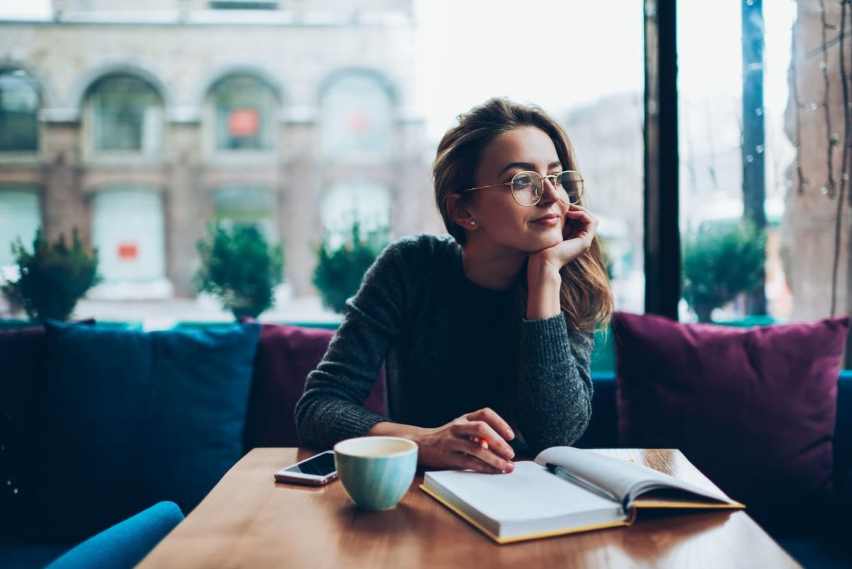 Woman writing her reflections in a journal. Woman writing her reflections in a journal.