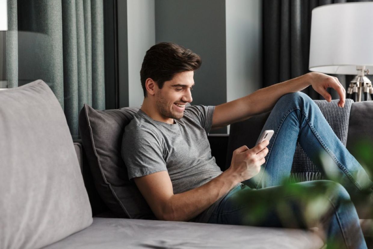 A man looks at his phone. A man looks at his phone.