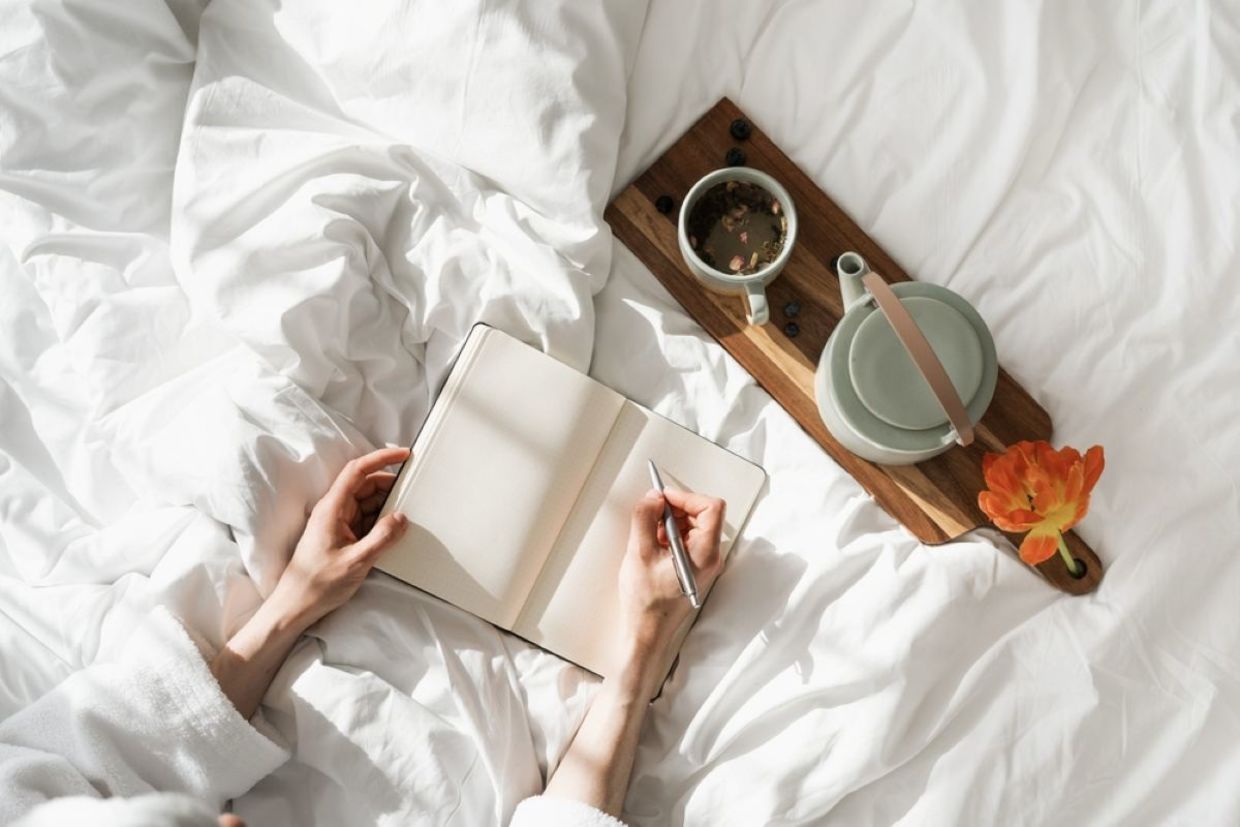 A person journals during the daytime.